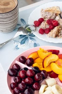 Breakfast setup with hot beverage, sliced fruit, and oatmeal served on patt.. Stock Photos