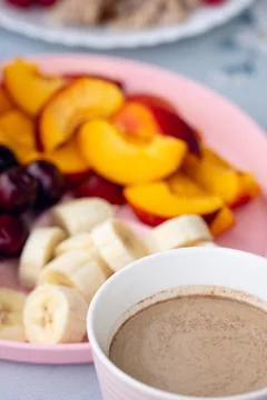 Breakfast setup with hot beverage, sliced fruit, and oatmeal served on patt.. Stock Photos