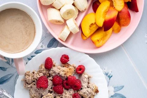 Breakfast setup with hot beverage, sliced fruit, and oatmeal served on patt.. Stock Photos