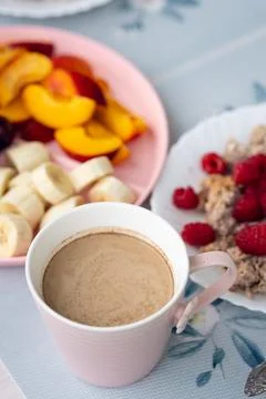 Breakfast setup with hot beverage, sliced fruit, and oatmeal served on patt.. Stock Photos