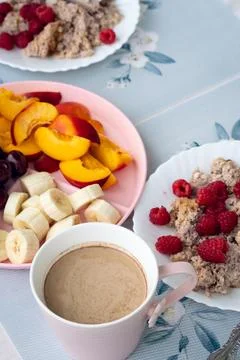 Breakfast setup with hot beverage, sliced fruit, and oatmeal served on patt.. Stock Photos