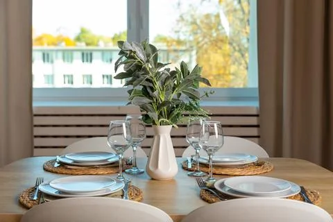 Breakfast setup on wooden table with nice vase and modern chair. Фото