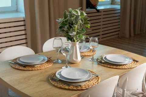 Breakfast setup on wooden table with nice vase and modern chair. Stock Photos