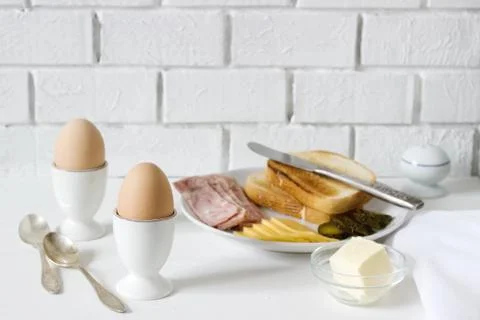 Breakfast with soft-boiled egg, bread toast, ham, cheese and canned cucumbers Stock Photos