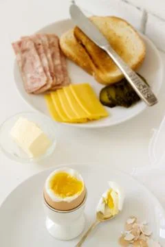 Breakfast with soft-boiled egg, bread toast, ham, cheese and canned cucumbers Stock Photos