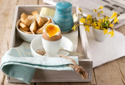 Breakfast from soft-boiled egg, bread toast, coffee with cream and fresh Stock Photos