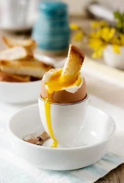Breakfast from soft-boiled egg, bread toast, coffee with cream and fresh Stock Photos