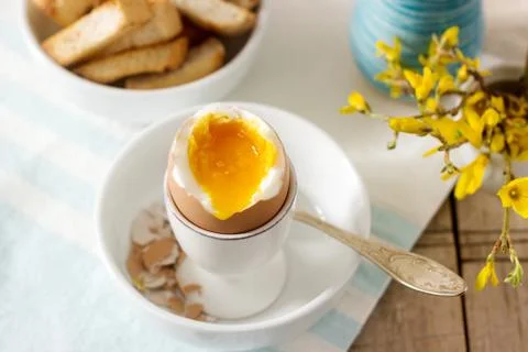 Breakfast from soft-boiled egg, bread toast, coffee with cream and fresh Stock-Fotos