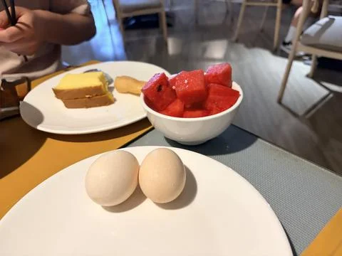 Breakfast with soft-boiled eggs, watermelon, and cheesecake. Stock Photos