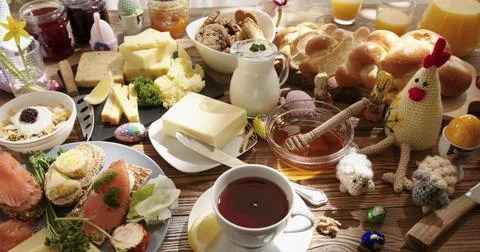 Breakfast spread with bread, cheese, fish, and eggs on a wooden table at a Stock Photos