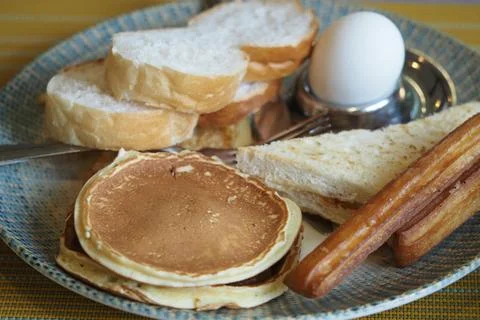 Breakfast spread on a plate with bread and pancakes Stock Photos