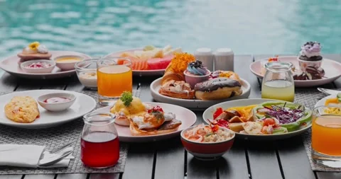 Breakfast spread sitting on table near resort swimming pool Stock-Footage 342333030