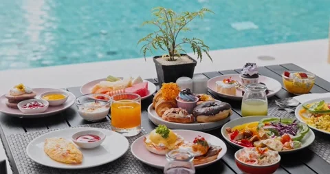 Breakfast spread on table by resort swimming pool Stock Footage 340547839