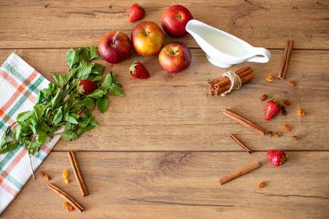 Breakfast table with apples, strawberries, milk, mint and cinnamon Stock Photos