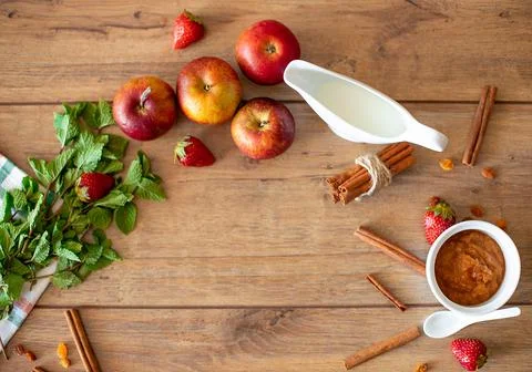 Breakfast table with apples, strawberries, milk, mint and cinnamon Foto stock