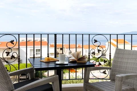 Breakfast table on a balcony overlooking red rooftops and the Adriatic Sea .. Stock Photos