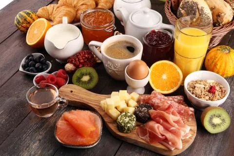 Breakfast on table with bread buns, croissants, coffe and juice Stock Photos
