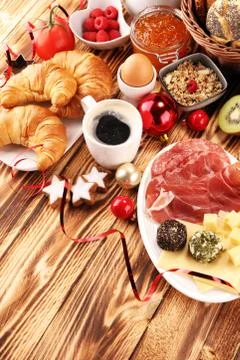 Breakfast on table with bread buns, croissants, coffe and juice on christmas  Stock Photos