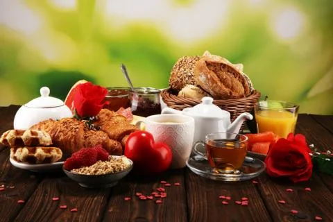 Breakfast on table with bread buns, croissants, coffe and juice on valentines Foto stock