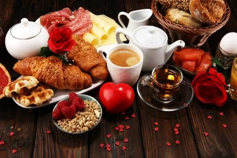 Breakfast on table with bread buns, croissants, coffe and juice on valentines Stock Photos