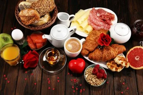 Breakfast on table with bread buns, croissants, coffe and juice on valentines Stock Photos