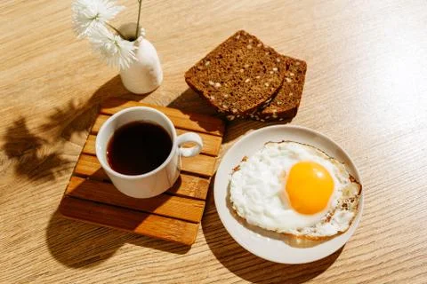Breakfast is on the table. A cup of tea. Fried egg and toast bread Fotos Stock