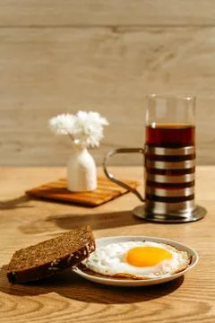 Breakfast is on the table. A cup of tea. Fried egg and toast bread Фото