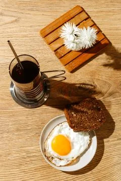 Breakfast is on the table. A cup of tea. Fried egg and toast bread 写真素材