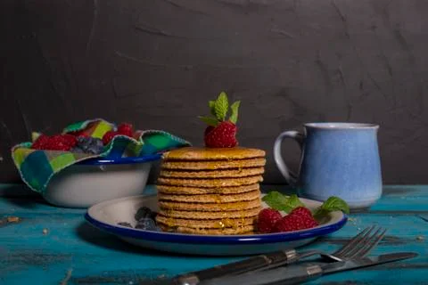 Breakfast table. Dutch waffle dish with raspberries, blueberries and honey wi Stock Photos