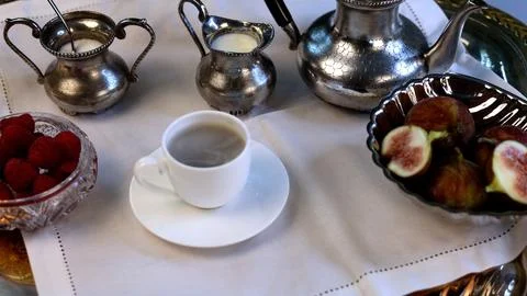 Breakfast table features vintage silver teapot with black handle, sugar jacks Stock Photos