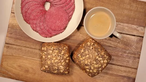 Breakfast table with fresh bread rolls and sausage - top down view Stock-Footage 151058572