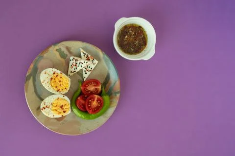 Breakfast table hard boiled egg on colorful plate with sliced tomato, pepper, Stock Photos