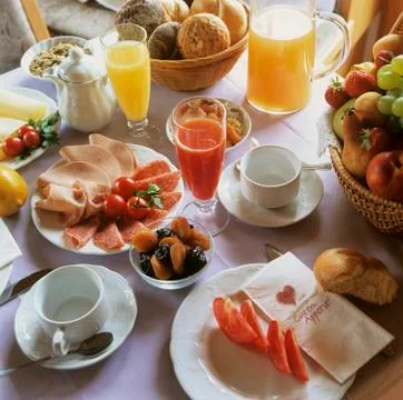 Breakfast table with juices, cold cuts and fruit Stock Photos
