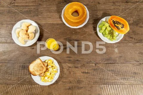 Breakfast table with papaya, grapes, toast and eggs. Stock Photos