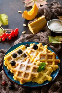 Breakfast table with pumpkin waffles and fresh blackberries on a stone. Stock Photos