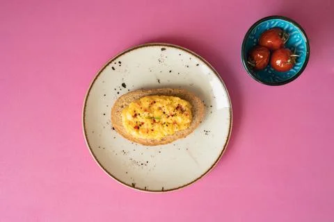 Breakfast table scrambled egg with toasted bread white plate and roasted toma Stock Photos