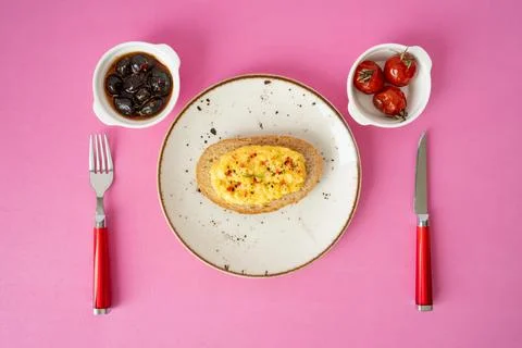 Breakfast table scrambled egg with toasted bread and black olives with sauce Stock Photos