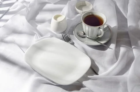 Breakfast table setting in white on sunny morning Stock Photos