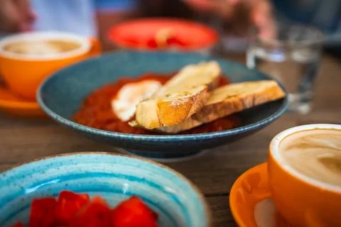 Breakfast table with shakshuka, toasted bread, and coffee Stock Photos