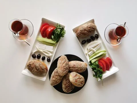 Breakfast table. Tea, donuts, olives, cheese, tomatoes, cucumbers. Stock Photos