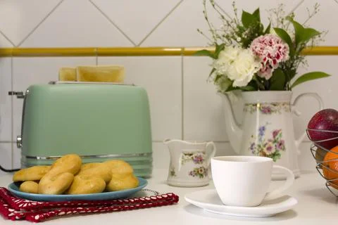 Breakfast table with toasted bread, cookies, coffee and fresh flowers Stock Photos
