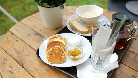Breakfast on the table by the window, pancakes and porridge Stock Footage 113232562