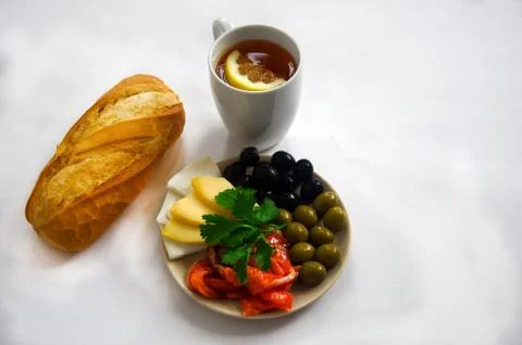 Breakfast - tea, bread, plate with red fish, cheese and olives Stock Photos