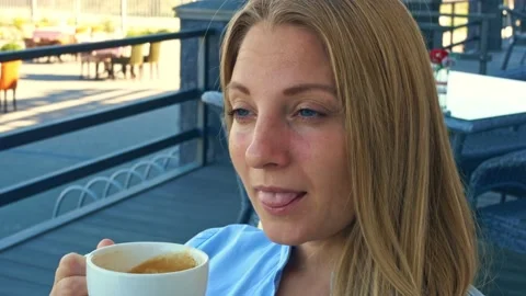 Breakfast on the terrace with an invigorating mug of coffee, a beautiful blonde Stock Footage 160492701