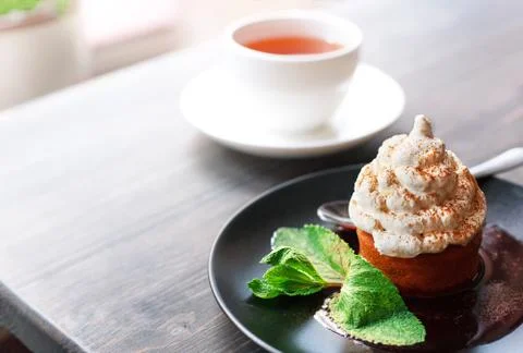 Breakfast time . Tea and cake with cream, mint leaves Stock Photos
