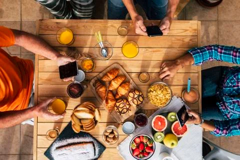 Breakfast time in vertical top view with family of friends eating together -  Stock Photos