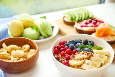 Breakfast top view white background. oatmeal with berries, toasts on a wooden Stock Photos