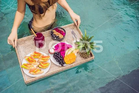 Breakfast tray in swimming pool, floating breakfast in luxury hotel. Girl Stock Photos
