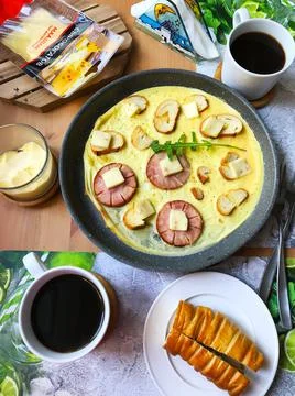 Breakfast with two cups of coffee, omelette, cheese, herbs and croissant. Foto stock
