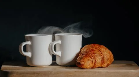 Breakfast for two. two cups of hot tea and fresh croissant Stock Photos